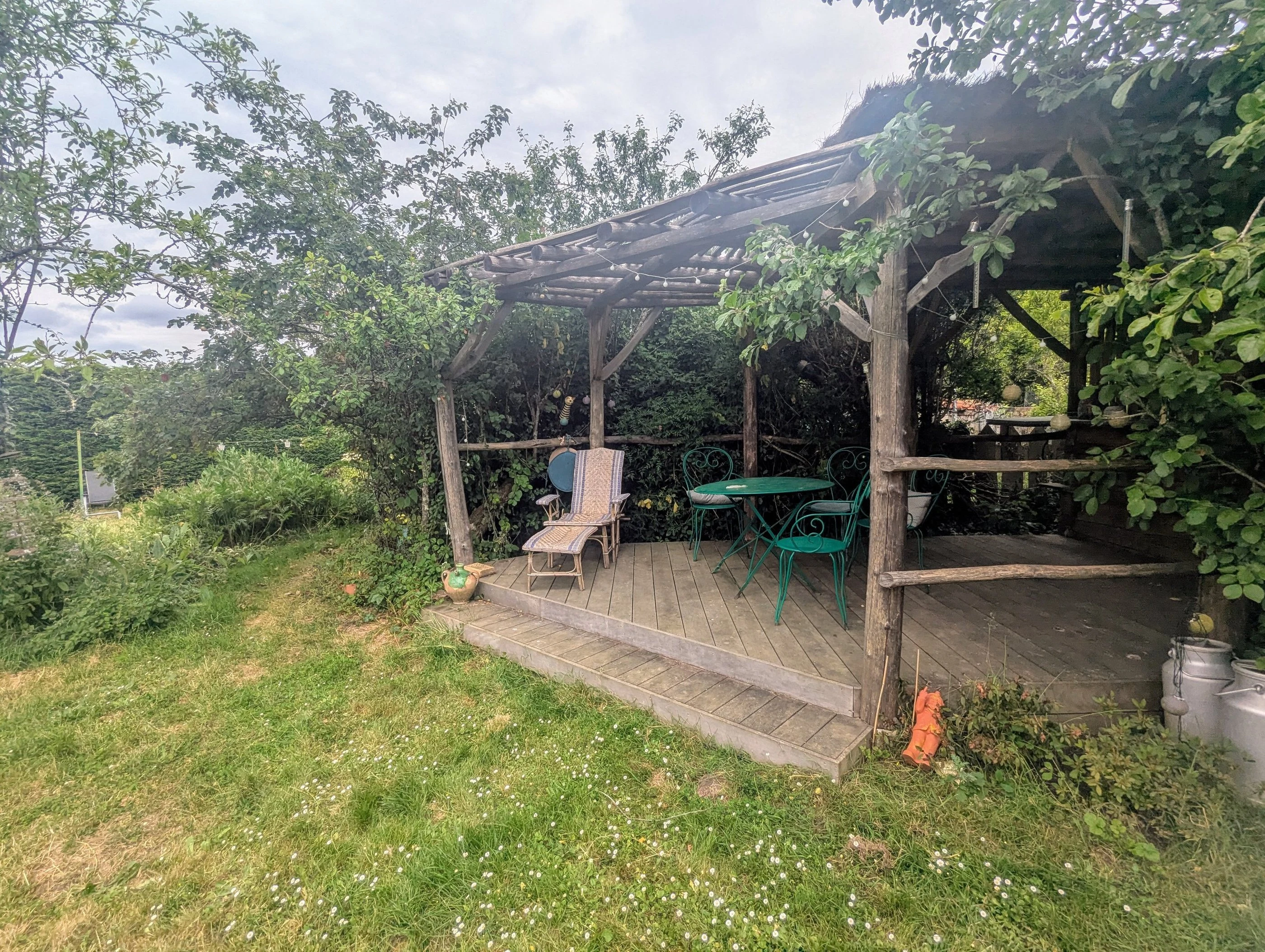Pergola du jardin avec table et chaises vertes