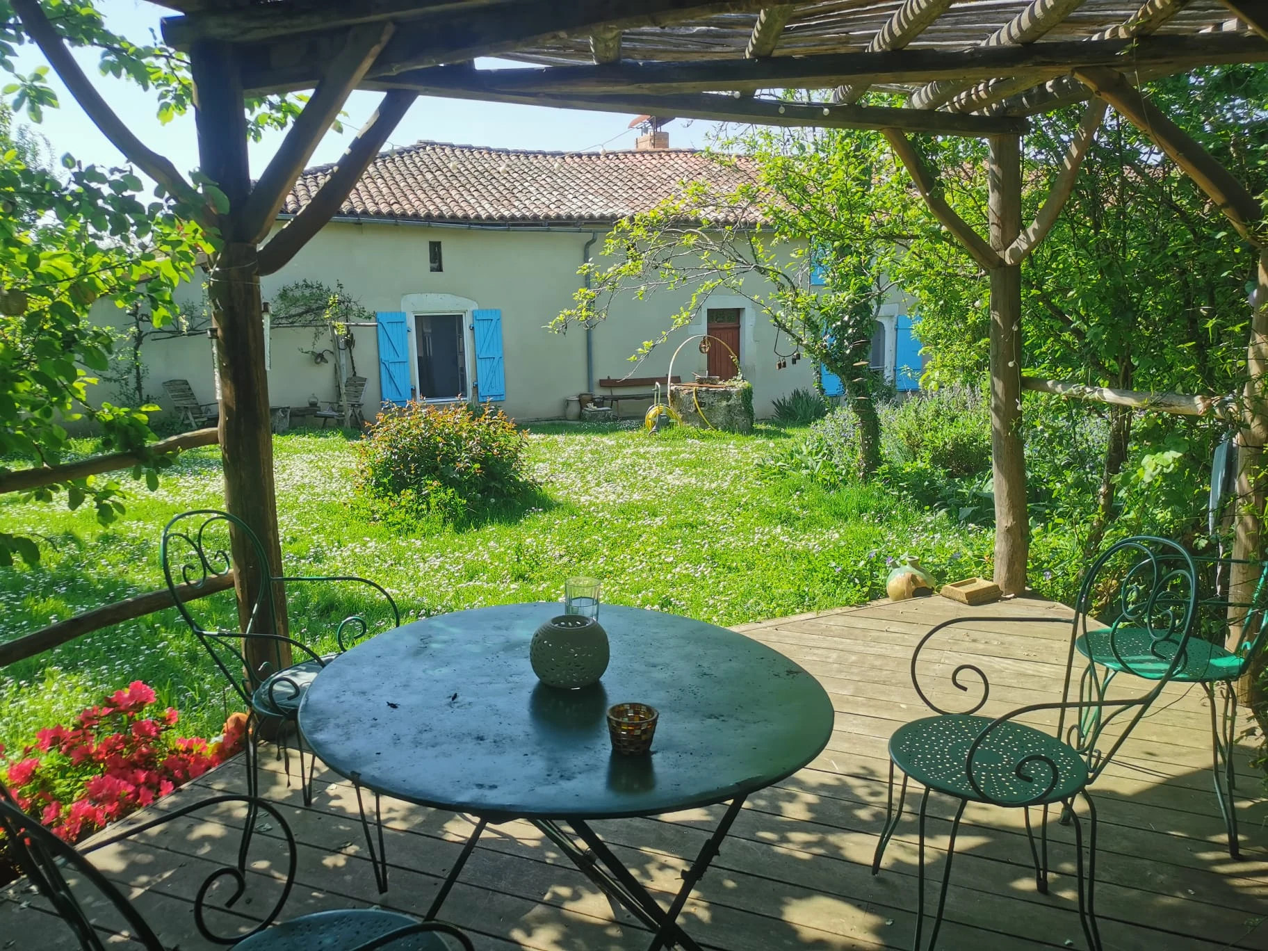 Terrasse en bois sous pergola à raisins avec table de jardin